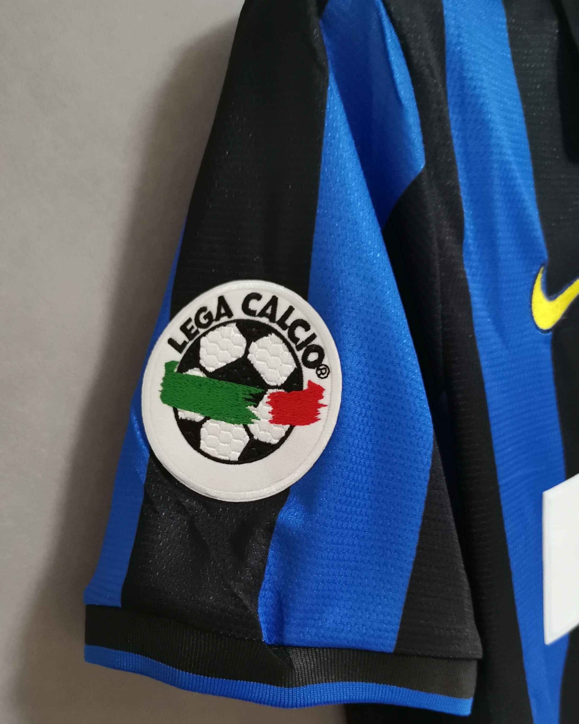 Dettaglio dello stemma dell'Inter con stella e trama del tessuto vintage 1998.