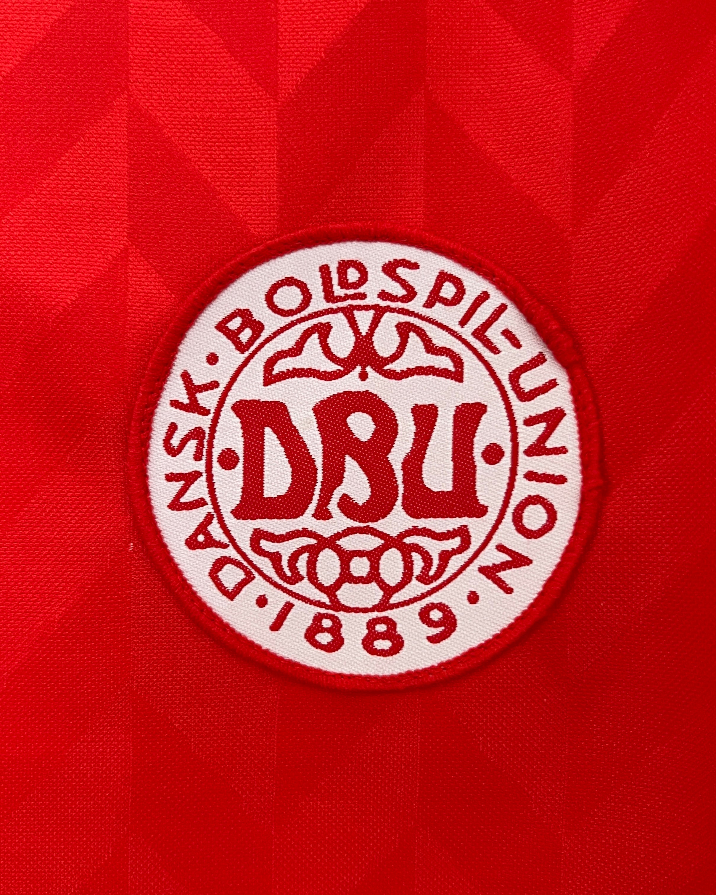 Dettaglio stemma Danimarca DBU su maglia home 2026 rosso Humme