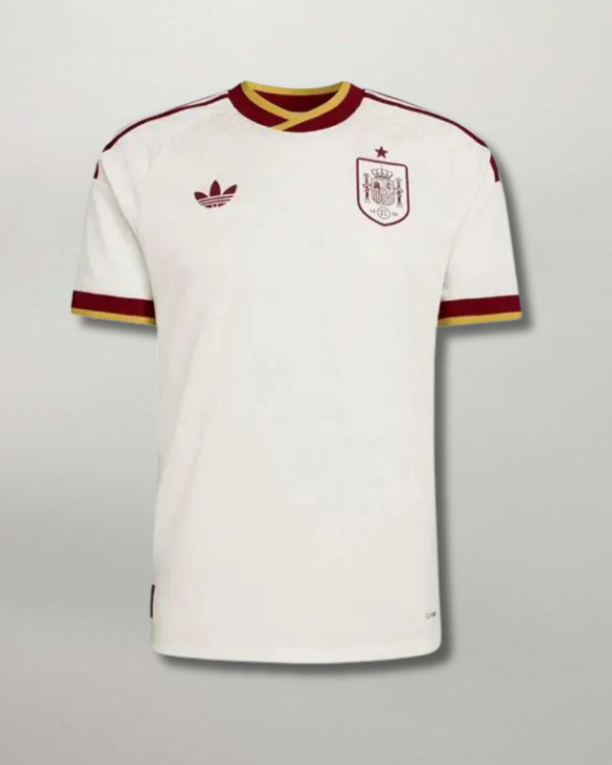 Fronte della maglia away della Spagna 2026 bianca con dettagli bicolore sul colletto e stemma centrale ricamato