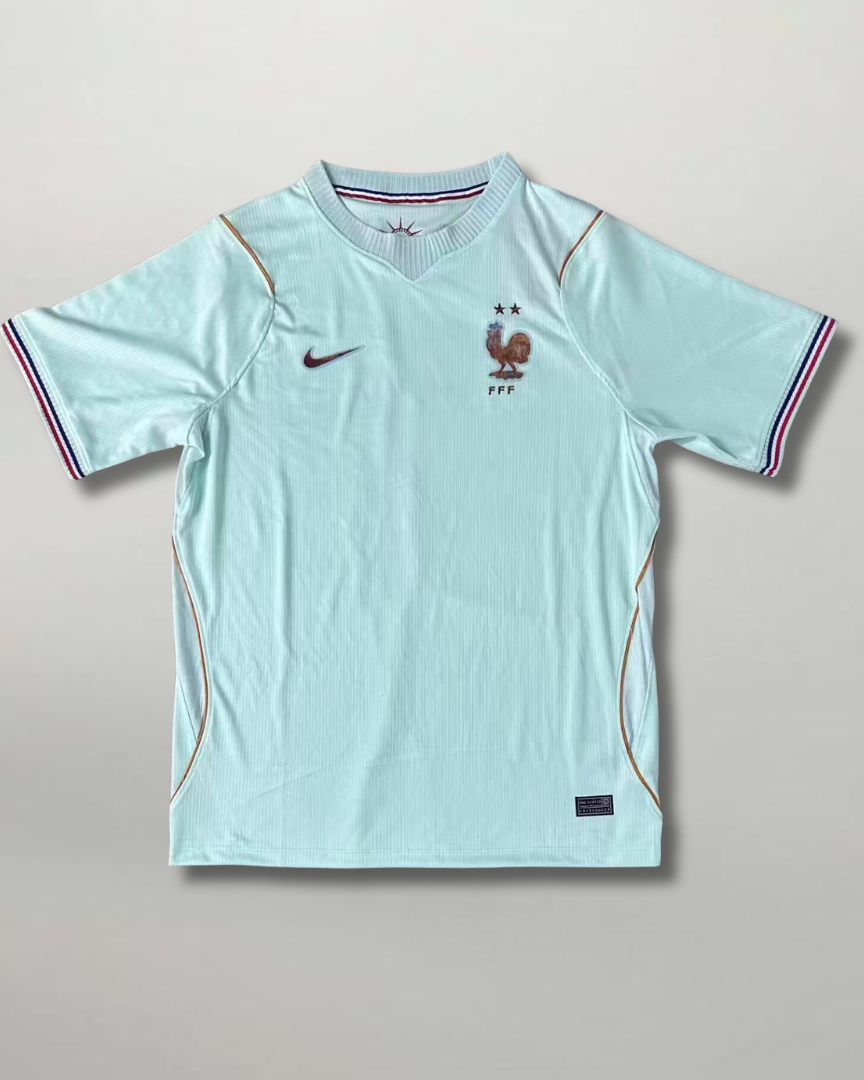 Fronte della maglia bianca away della Francia 2026 con sottili righe verticali sfumate e stemma sul petto