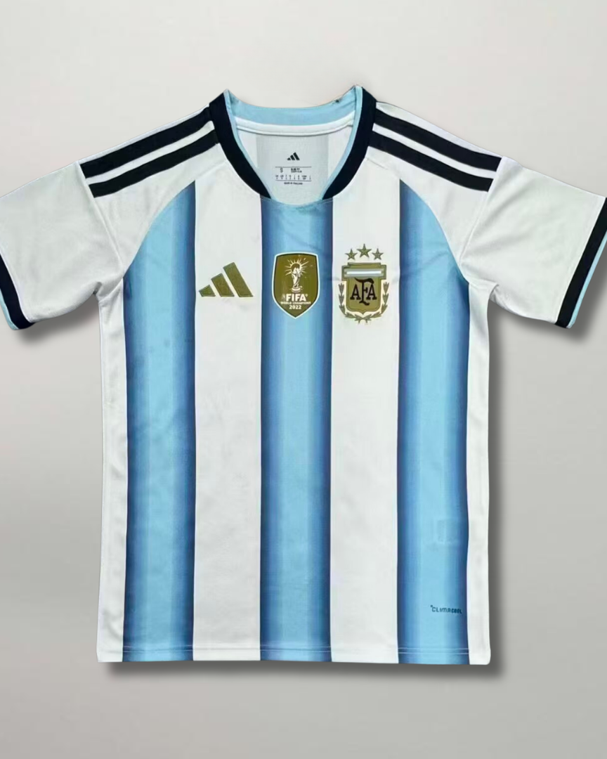 Fronte della maglia home Argentina 2026 a strisce bianche e celesti con dettagli dorati e stemma ricamato sul petto