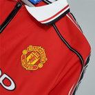 Dettaglio stemma Manchester United su maglia home 1998/99
