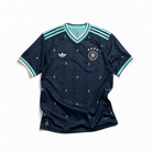 Fronte della maglia away della Germania 2026 verde scuro con dettagli menta sul colletto e stemma ricamato sul petto