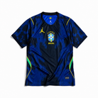 Fronte della maglia away Brasile 2026 blu con grafica astratta all-over, dettagli verde fluo e stemma stellato
