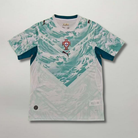 Fronte della maglia away del Portogallo 2026 bianca con pattern grafico azzurro ispirato alle azulejos e stemma centrale