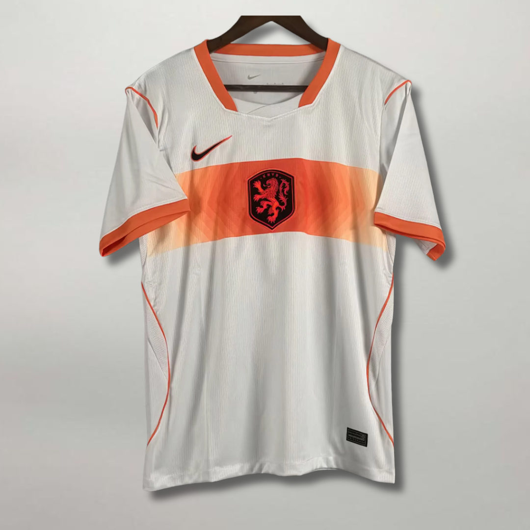Fronte della maglia away dell'Olanda 2026 chiara con fascia orizzontale arancione sul petto e stemma del leone