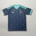 Fronte della maglia away della Germania 2026 verde scuro con dettagli menta sul colletto e stemma ricamato sul petto