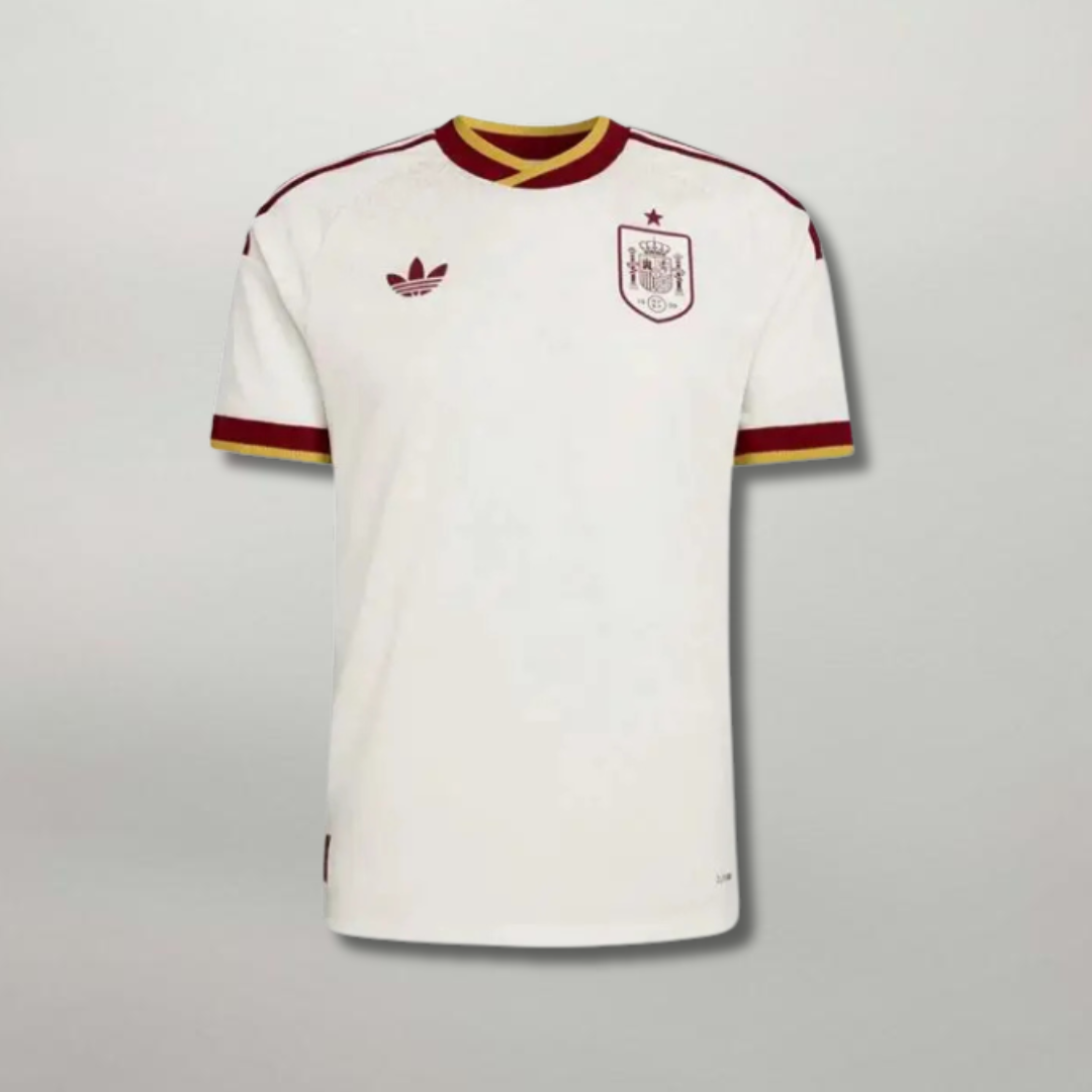 Fronte della maglia away della Spagna 2026 bianca con dettagli bicolore sul colletto e stemma centrale ricamato