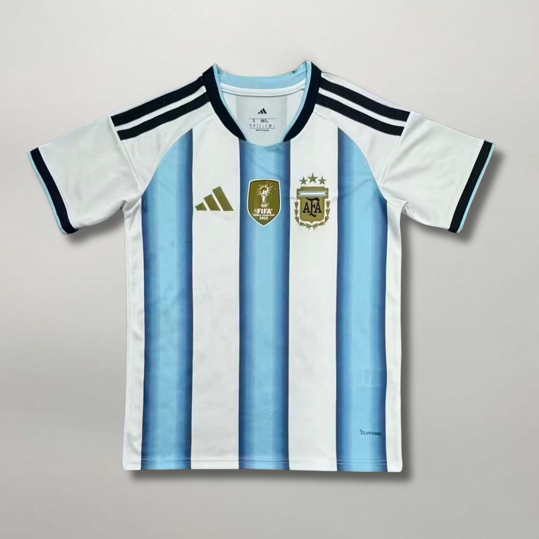Fronte della maglia home Argentina 2026 a strisce bianche e celesti con dettagli dorati e stemma ricamato sul petto