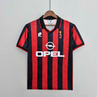 Fronte maglia rossonera Milan 1995/96 con strisce verticali e colletto a polo scuro.