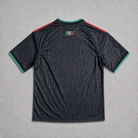 Retro maglia third El Tri FIFA World Cup 2026 — tessuto nero con trama decorativa ispirata alla cultura azteca, maniche corte con profili tricolori sulle spalle
