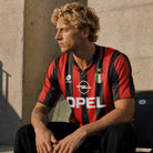 Fronte maglia Milan 1995/96 con strisce rosse e nere, colletto a polo e Scudetto.