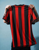 Dettaglio dello stemma del Milan con stella dorata e patch Scudetto tricolore.