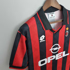 Milan con stella dorata su tessuto a strisce rosse e nere.