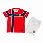 Norvegia Completo Home 2026 World Cup Bambino con maglia rossa e pantaloncini bianchi vista posteriore.