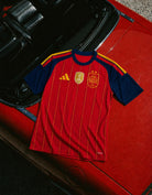 Maglia Home Spagna Vittoria Mondiali 2026 appesa con vista completa del design.