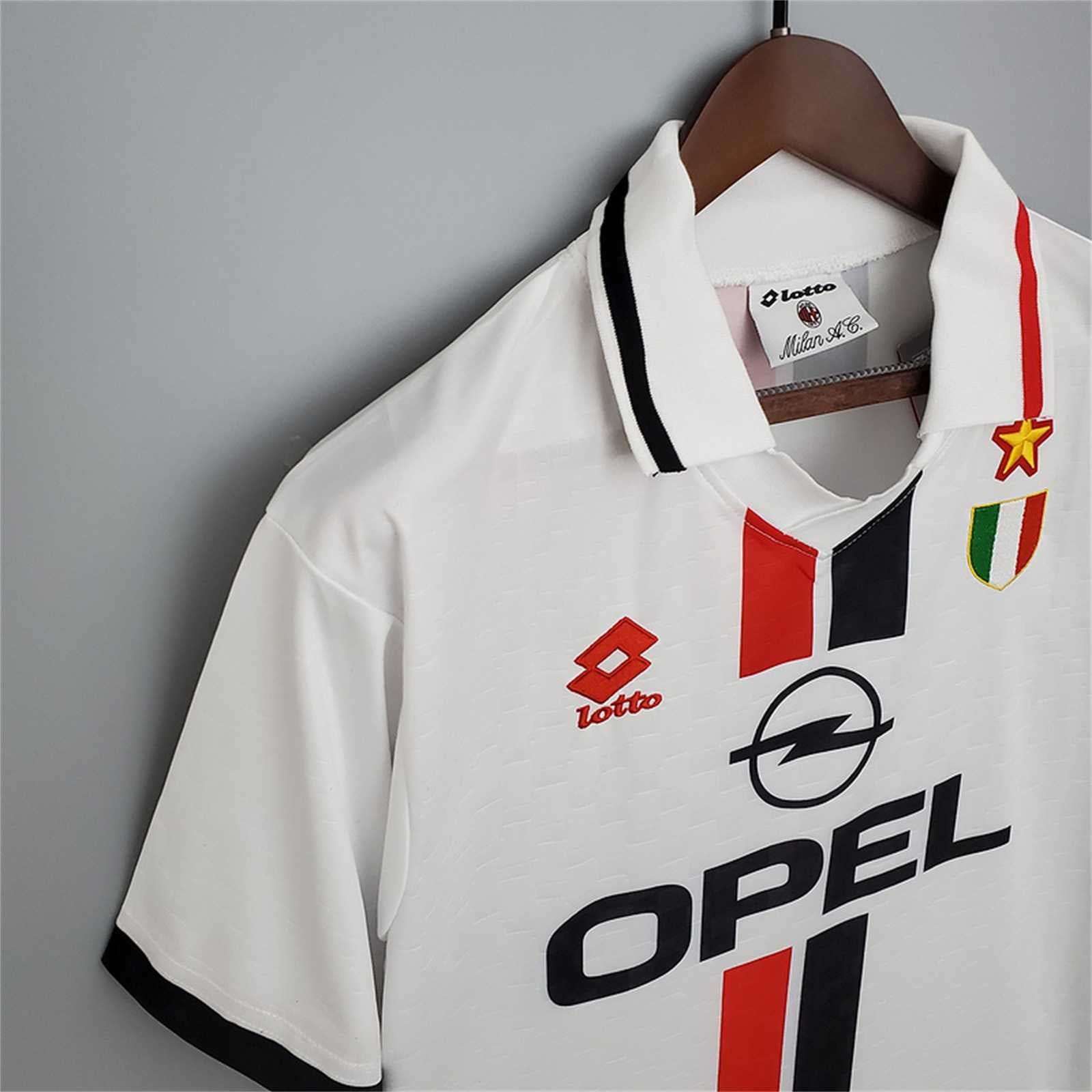 polo bianco e dello Scudetto ricamato su kit Milan 1996/97.